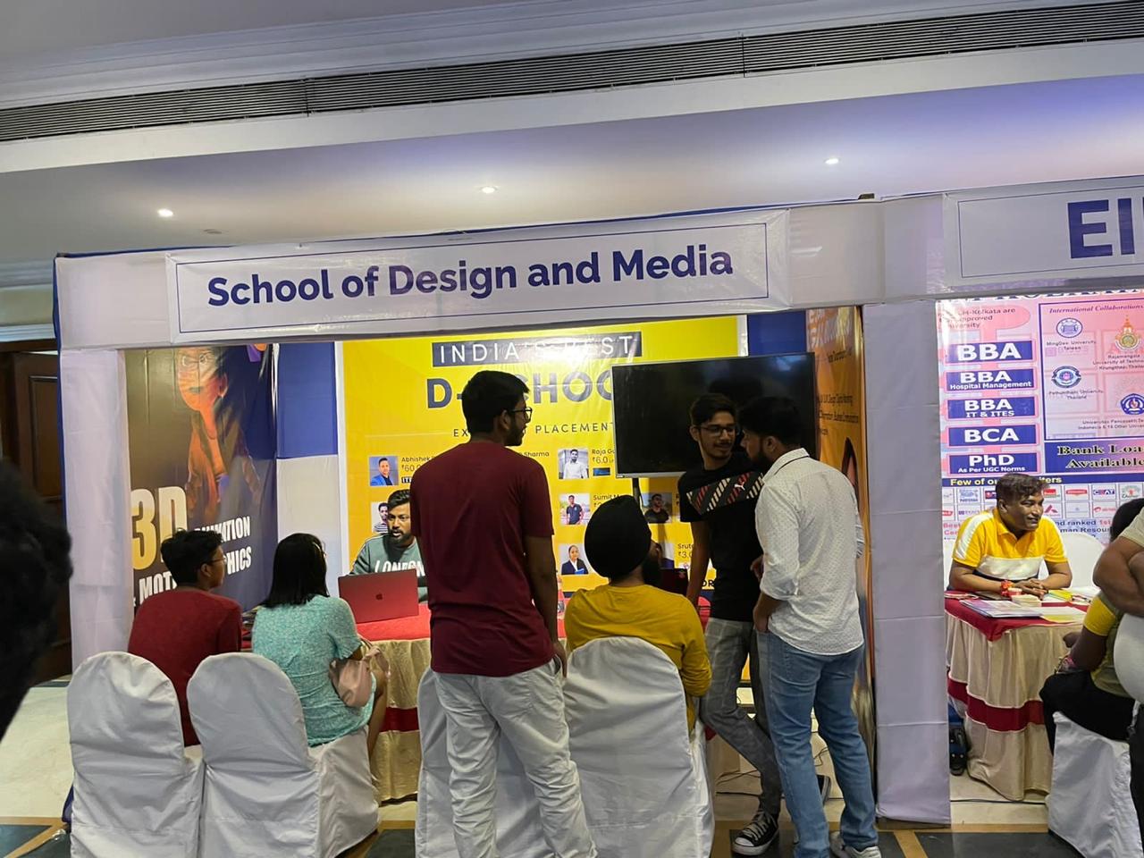 Wide shot of exhibition hall with colorful college booths