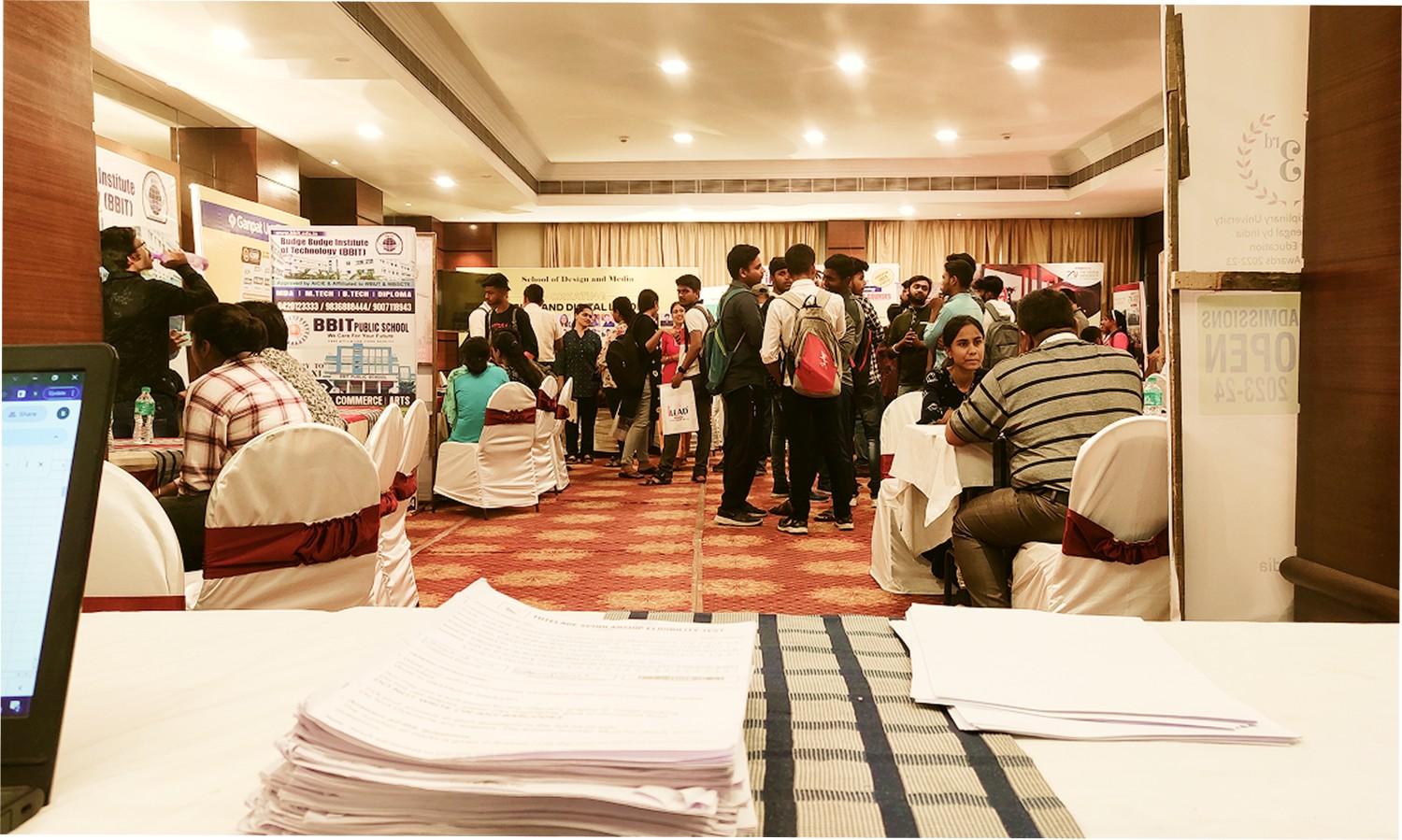 Attendees talking with university representatives