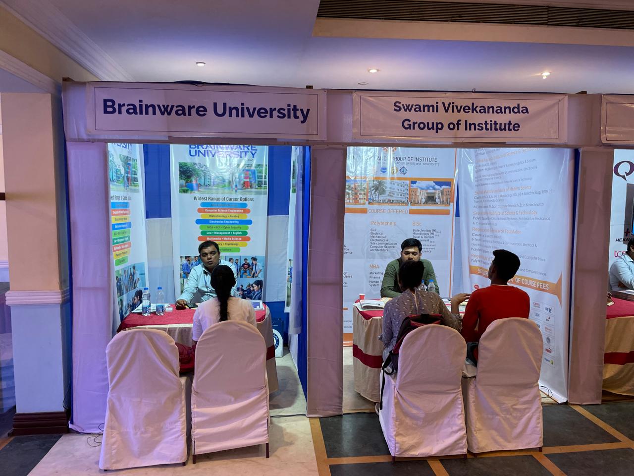 Attendees talking with university representatives