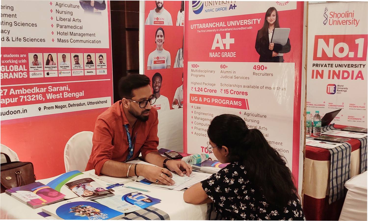 Families visiting a busy education fair floor